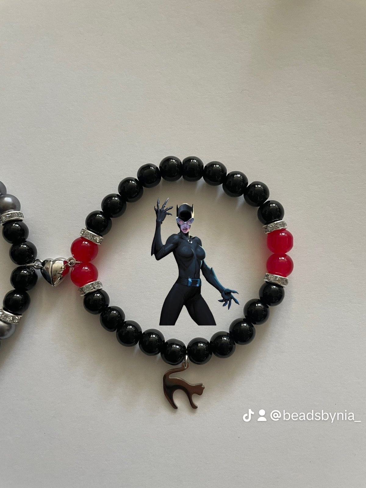 Close-up of the Catwoman bracelet in black and red beads with cat charm - Beads by Nia