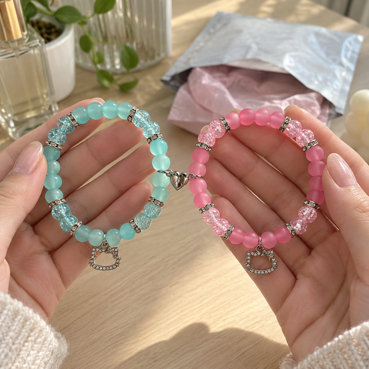 Two hands holding mint and pink Hello Kitty matching bracelets - Beads by Nia