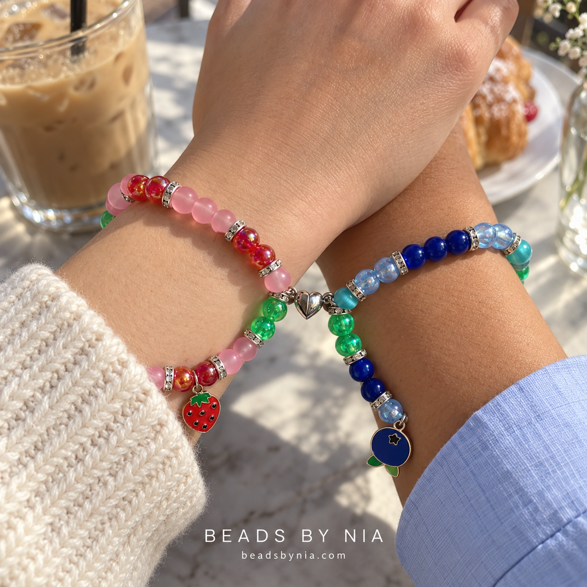 Two wrists wearing Strawberry Shortcake and Blueberry Muffin matching bracelets