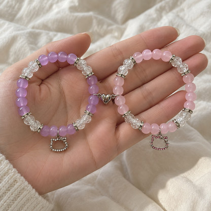 Hands holding purple and pink Hello Kitty matching bracelets - Beads by Nia