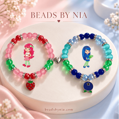 Strawberry Shortcake and Blueberry Muffin beaded bracelets on a cream podium - Beads by Nia