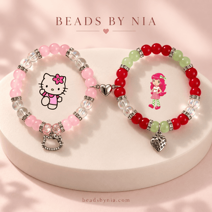 Hello Kitty and Strawberry Shortcake beaded bracelets on a cream podium - Beads by Nia