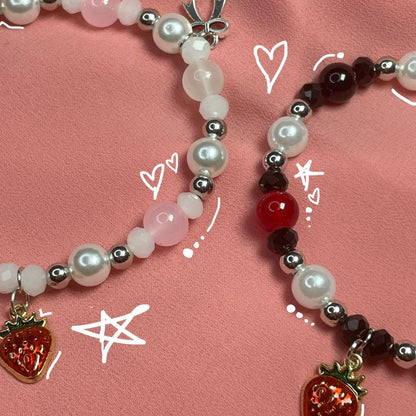 Close-up of Nana and Hachi beaded bracelets in red, black and pearl on pink - Beads by Nia