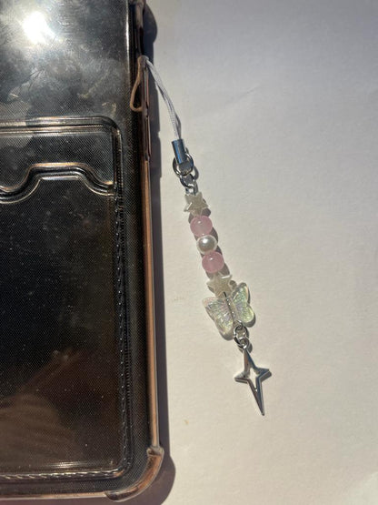 Dream catcher phone charm with pink beads and butterfly and star pendants on a phone case